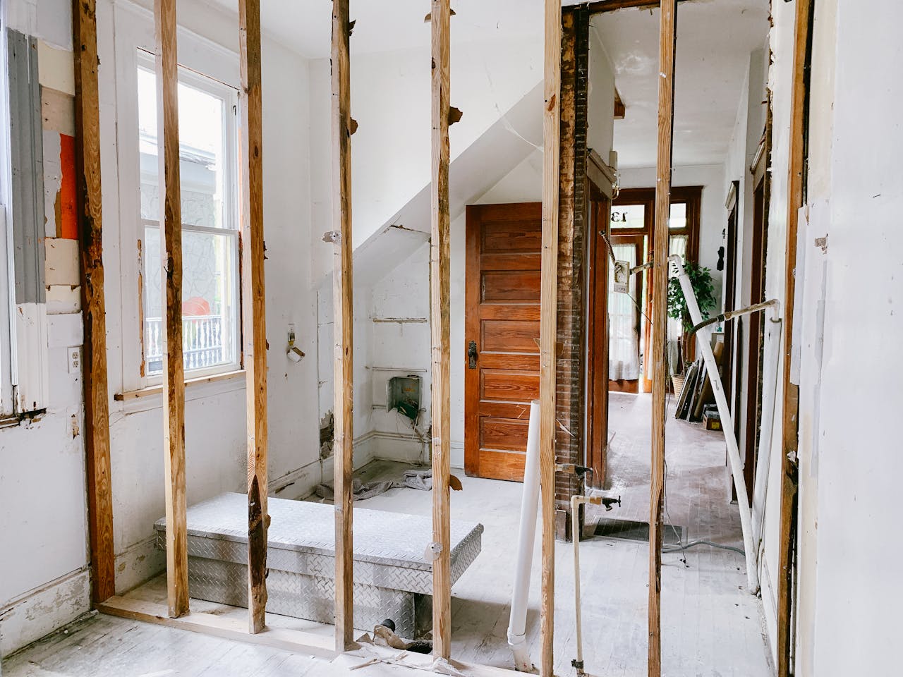 heros-img Interior view of a home under renovation with exposed wooden beams and door.