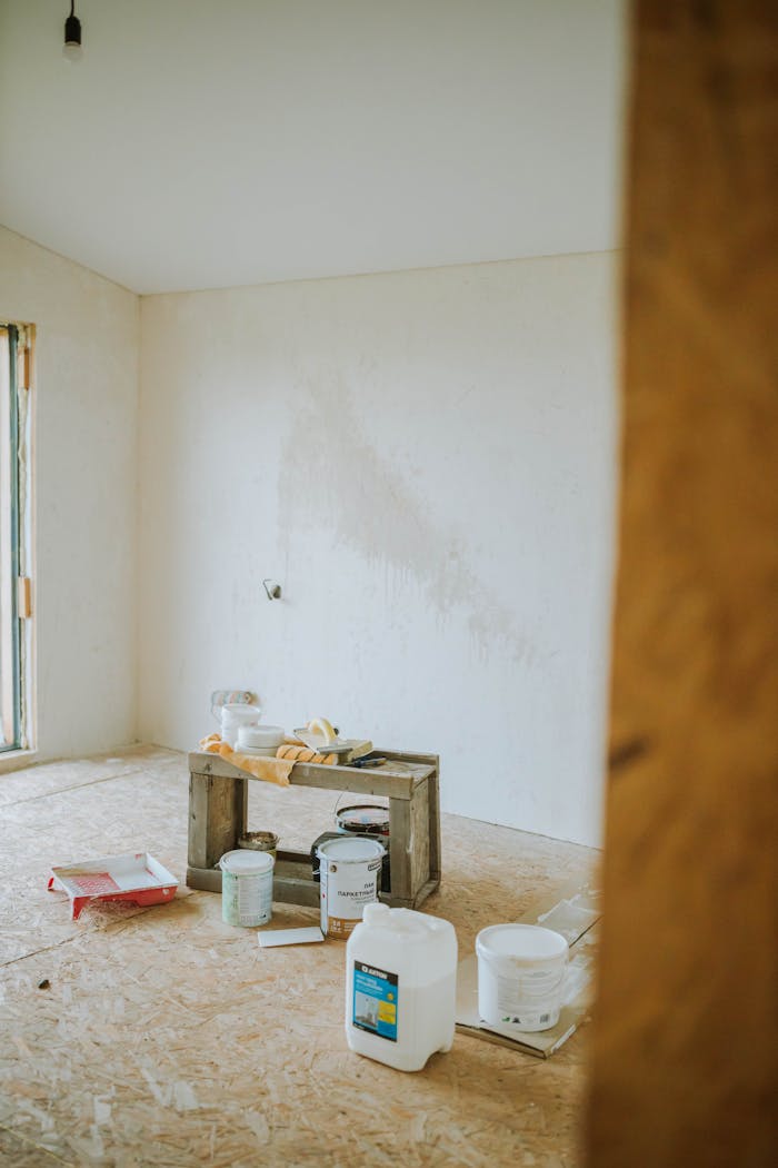 A serene room setup with paint cans and wooden crate suggests a work-in-progress renovation.